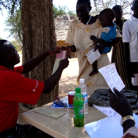 A Save the Children worker dispensing monetary aid in 2008.