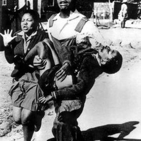 Schoolchildren fleeing after police shot the one being carried.