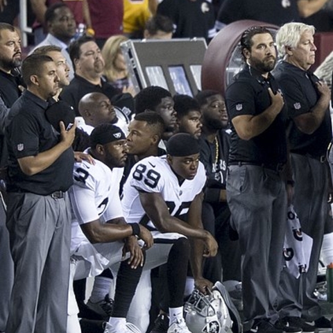 Oakland Raiders players kneel during the National Anthem.