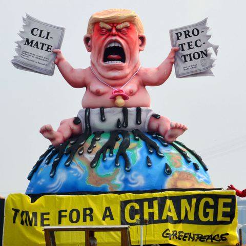 Sculpture of Donald Trump ripping up the Paris climate agreement.