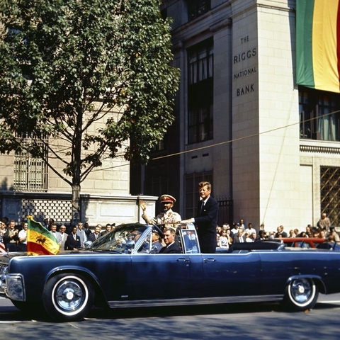 Ethiopian Emperor Haile Selassie waves to crowds lining Pennsylvania Avenue.