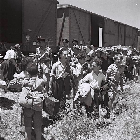 Children orphaned during the Holocaust arrive by train.