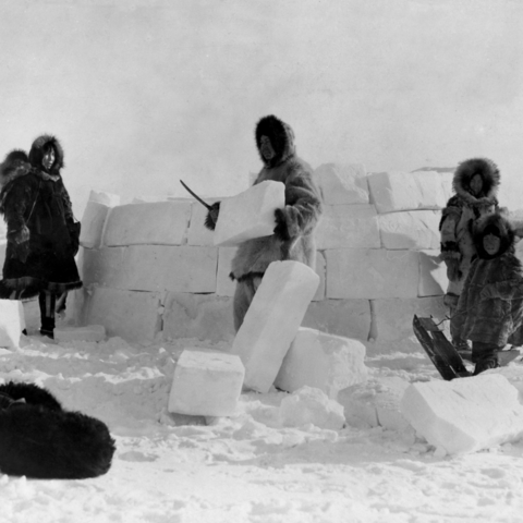 A group of Inuit people constructing an igloo.