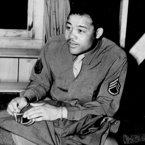 Joe Louis sews on the stripes of a technical sergeant to his army uniform.