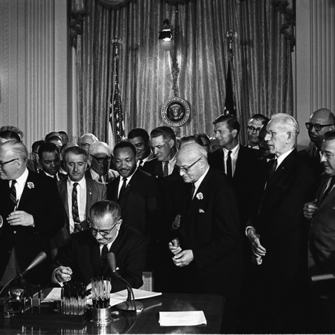 Lyndon B. Johnson signs the Civil Rights Act of 1964.
