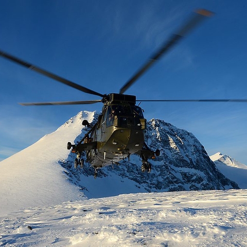 A Royal Navy helicopter carrying out load lifting training.