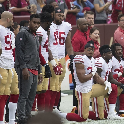 Members of the San Francisco 49ers kneel during the National Anthem.