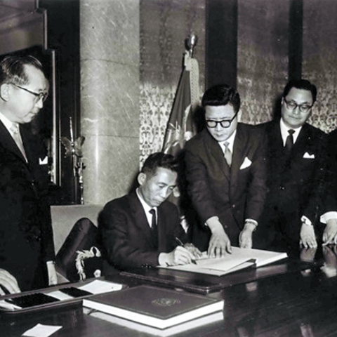 President Park Chung Hee signs the treaty to normalize relations between Korea and Japan.
