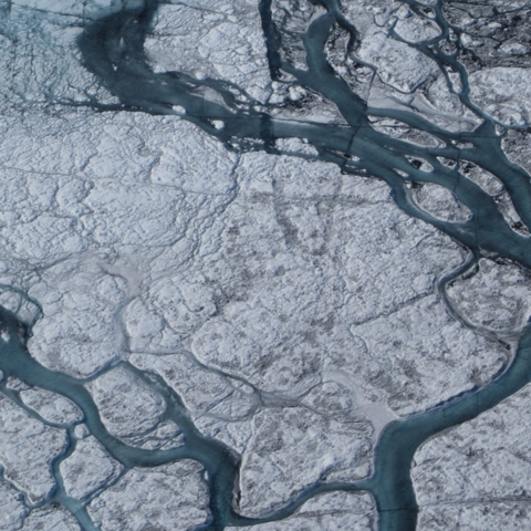 A large stream of meltwater emerges from an upstream supraglacial lake.