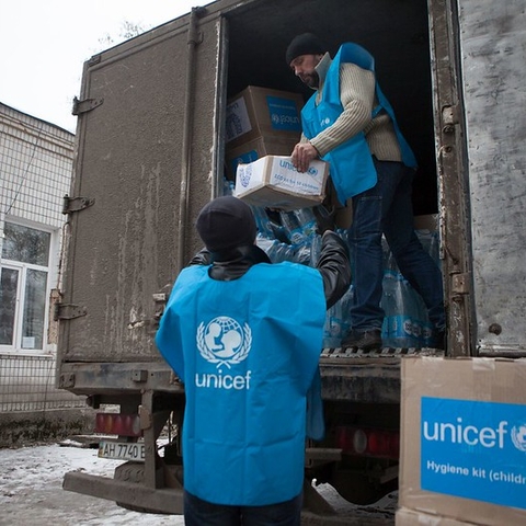 UNICEF workers unload and distribute humanitarian supplies.