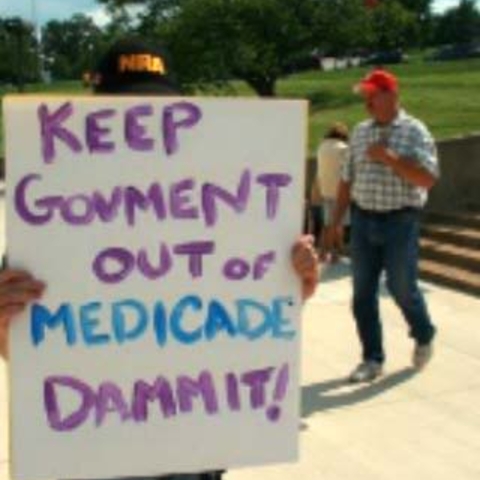 A sign that reads, "Keep Govment out of Medicade Dammit!"