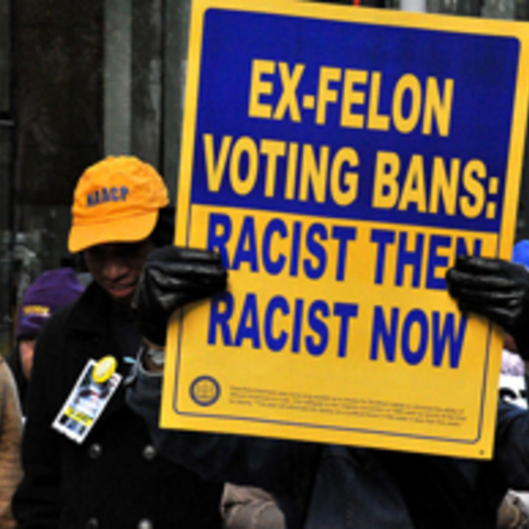 person holding sign that says ex-felon voting bans - racist then racist now