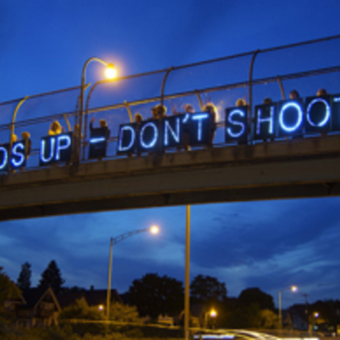 sign on bridge that states - hands up dont shoot