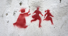 Stenciled graffiti of a priest pursuing two children