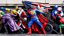 Monument with figures dressed as pop culture figures like Superman, Santa, and Ronald McDonald