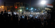 A crowd of protesters at night in Sudan