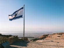 Flag of Israel with landscape of Israel in the background